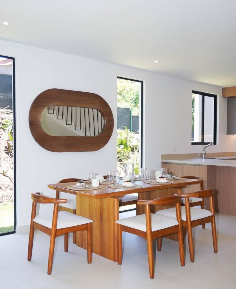 Comedor iluminado con mesa de madera y espejo decorativo, en casa de 385 Francosta en Barreal de Heredia.