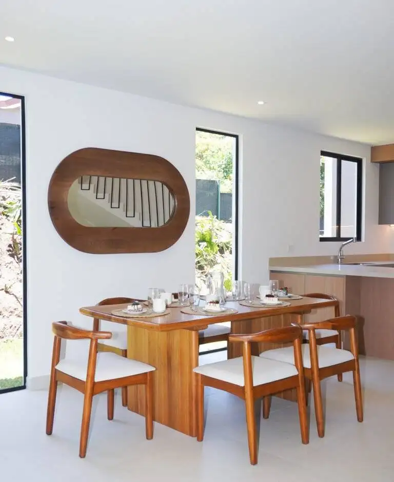 Comedor iluminado con mesa de madera y espejo decorativo, en casa de 385 Francosta en Barreal de Heredia.
