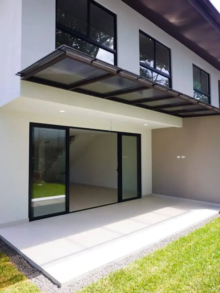 Patio trasero techado con puertas corredizas y ventanales, en casa de 385 Francosta, Barreal de Heredia.